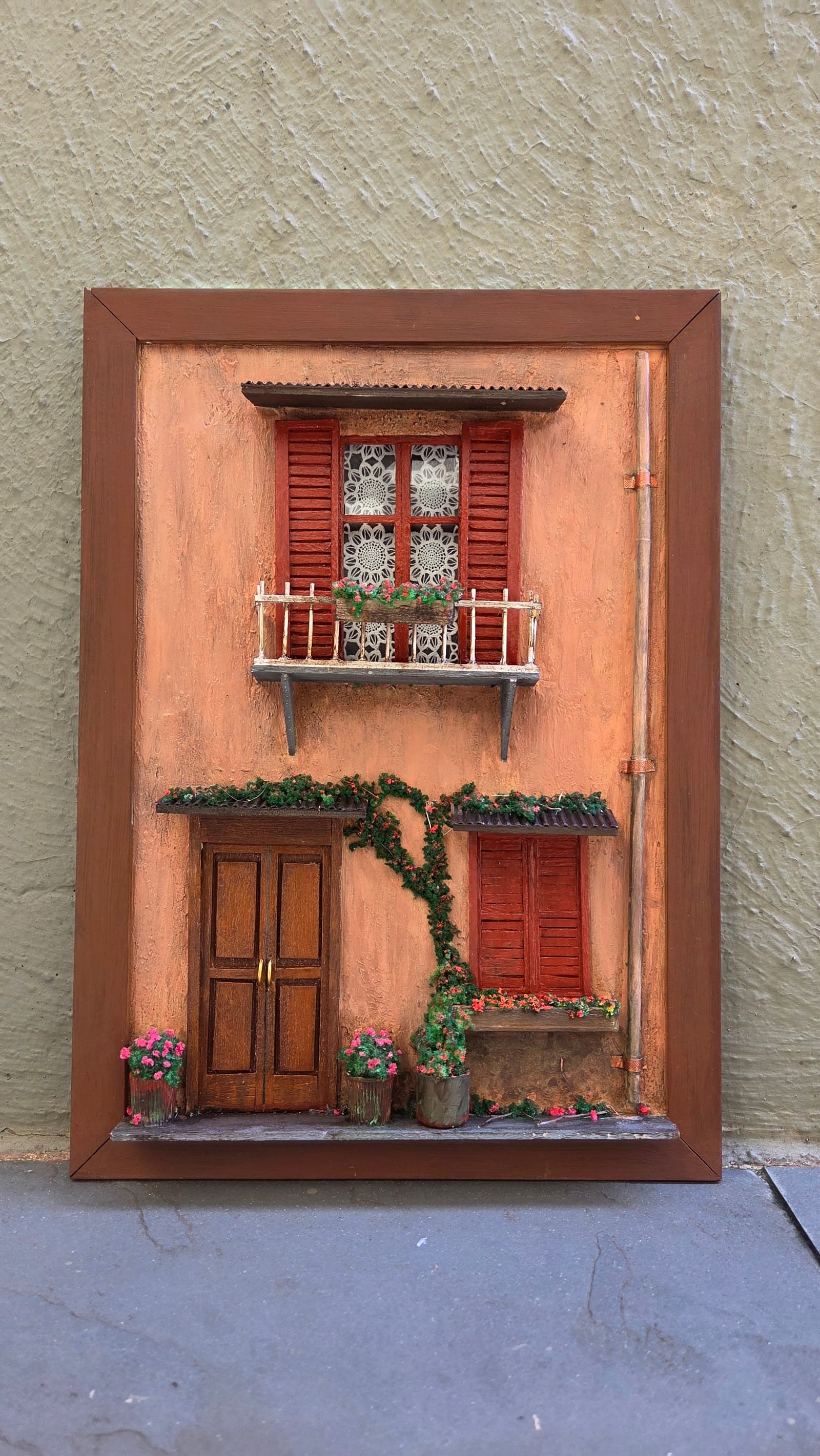 Fachada italiana em moldura com parede terracota, venezianas vermelhas, sacada, trepadeira e porta de madeira — vista frontal