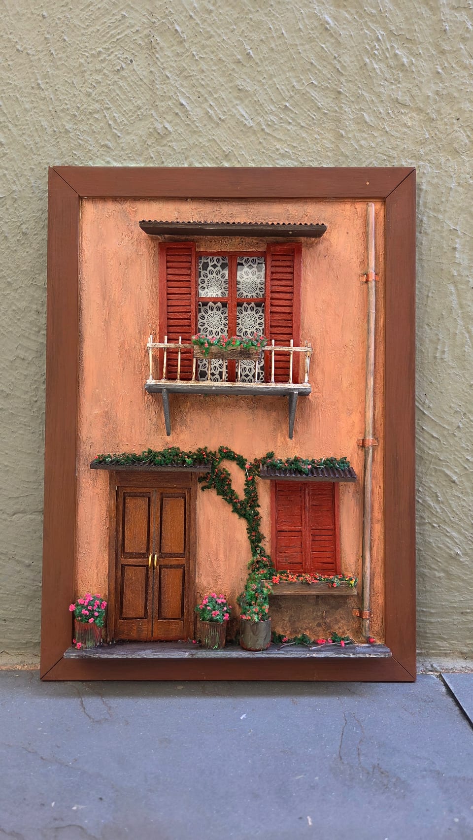 Fachada italiana em moldura com parede terracota, venezianas vermelhas, sacada, trepadeira e porta de madeira — vista frontal